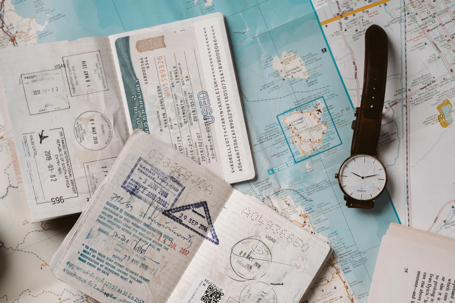 Passports, maps, boarding passes, and coins laid out for trip planning
