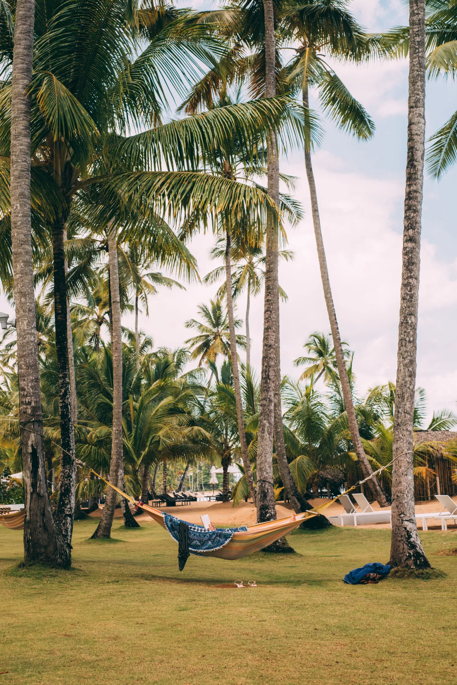 Traveler relaxing in a hammock among palm trees at a beach resort