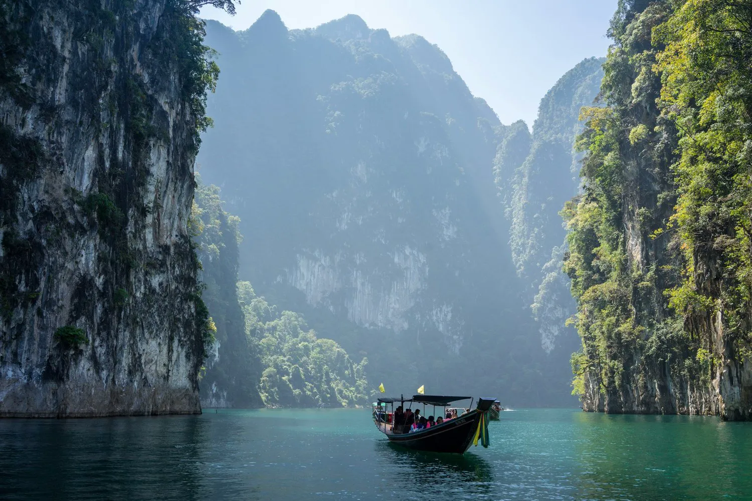 Longtail boat on a lagoon between limestone cliffs